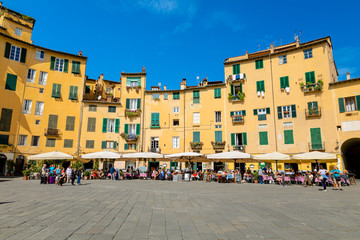 Lucca, Tuscany / Italy - October 10, 2019: View of Piazza dell'Anfiteatro, a famous elliptical square in the historic centre of Lucca, with one of the four arched gateway in a sunny autumn day