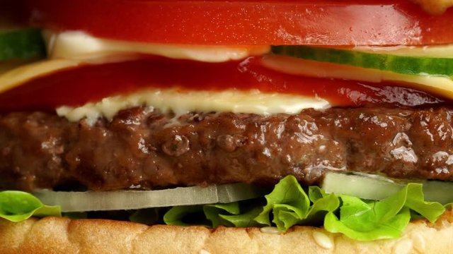 Juicy beef burger with cutlet, onion, vegetables, melted cheese, lettuce, sauce