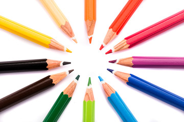 Fototapeta premium High angle view of colored circle shaped pencils in a row over white background