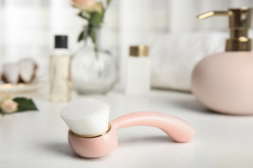 Stylish face cleansing brush on white table. Cosmetic accessory