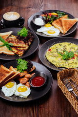 Breakfast food table. Festive brunch set, meal variety with fried egg, pancakes, croissants, smoothie ,fresh berries and fruits. Overhead view