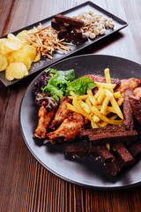 a large plate with a wide selection of snacks for beer on wooden table