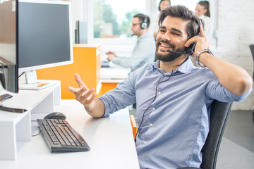 Fototapeta premium Smiling sales agent with headset talking to client in call centre