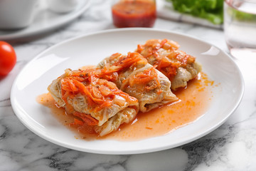 Delicious cabbage rolls served on white marble table, closeup