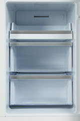 Shelves of empty modern refrigerator, closeup view