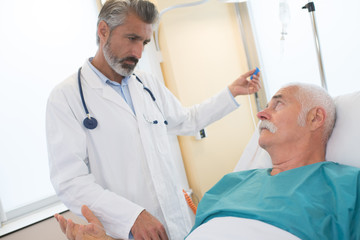Fototapeta premium doctor in hospital room looking at patient