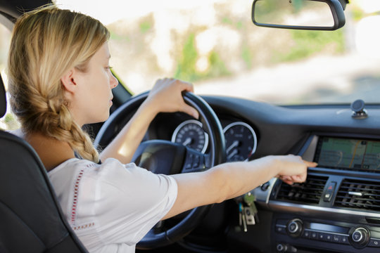 Woman Changing Radio Station In Her Car