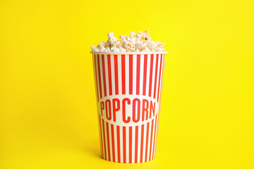 Tasty fresh pop corn on yellow background