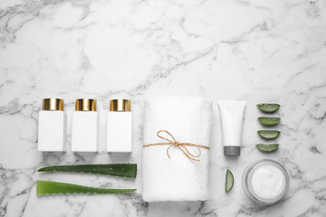 Flat lay composition with aloe vera and cosmetic products on white marble background. Space for text