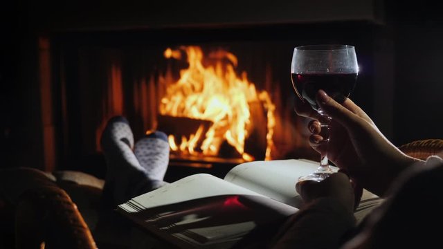 Sitting by the fireplace with a blank notebook and a glass of wine - planning a new life concept