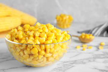 Delicious canned corn in bowl on marble table, closeup