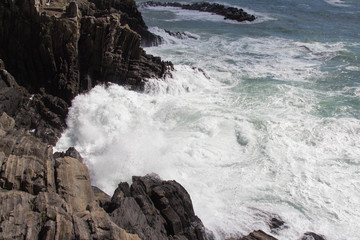 Wave are crashing on group of stones.