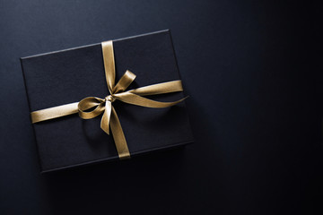 Gift wrapped in dark paper on dark background