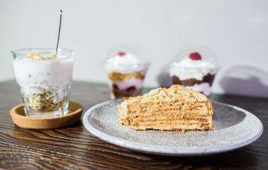 A slice of Esterhazy cake with yogurt and raspberries on a large wooden table