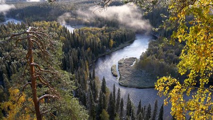 Oulanka National Park, Finland. River and evergreen forest with clouds during sunrise in autumn. UHD