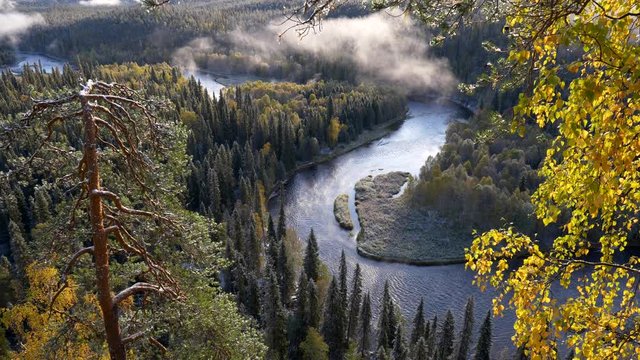 Oulanka National Park, Finland. River and evergreen forest with clouds during sunrise in autumn. UHD