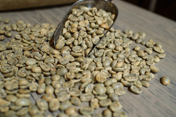 Fresh green coffee beans on a wooden table in a cozy coffee shop