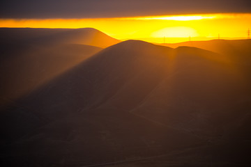 Cloudy weather. Zoom shot. Orange sunset view at mountains in Azerbaijan