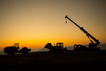 Abstract Industrial background with construction crane silhouette over amazing sunset sky. Mobile...