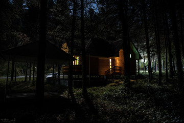 Old spooky house at the pine forest at night. Horror Halloween concept