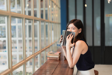 Asian woman reading a book at the coffeeshop.