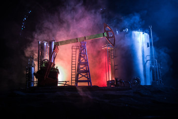 Artwork decoration. Oil pump and oil rig energy industrial machines for petroleum at night with fog and backlight. Oil refining factory. Energy industrial concept. Selective focus