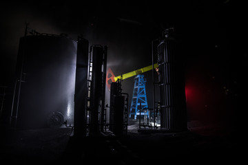 Artwork decoration. Oil pump and oil rig energy industrial machines for petroleum at night with fog and backlight. Oil refining factory. Energy industrial concept. Selective focus