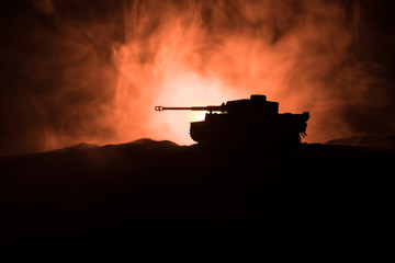 War Concept. Military silhouettes fighting scene on war fog sky background, Silhouette of armored vehicle below Cloudy Skyline At night. Attack scene. Tanks battle.
