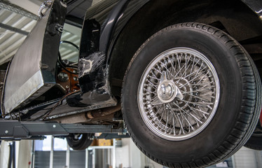 Fototapeta premium Oldtimer mit Speichenfelgen in der Werkstatt