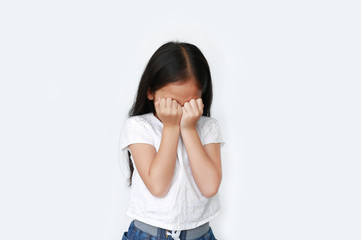 Little girl closing hid eyes by hand isolated over white background. Kid is crying and rubbing her eyes with her hands.