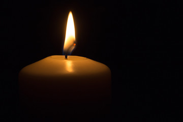 eine brennende Kerze im dunkeln