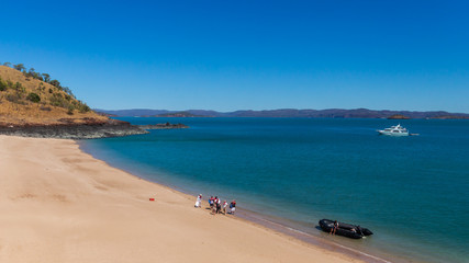 Tourists from a luxury expedition cruise ship  explore a remote beach on Naturalist Island in the Kimberley before a sightseeing flight over Prince Frederick Harbour.
