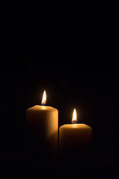 zwei brennende Kerzen im dunkeln