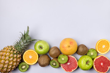 Tropical Fruits on Blue Background Ripe Pineapple Kiwi Oranges Grapefruits Geen Apples Healthy Food Vitamin Diet or Detox Concept Flat Lay Top View Copy Space