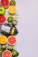 Green Fruits and Vegetable Citrus Glass Mug Straw on Blue Background Detox or Diet Concept Green Apple Broccoli Kiwi Green Apple Grapefruits Ingredient for Smoothie or Juice Top View Flat Lay Vertical
