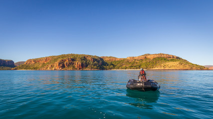 A Zodiac aproaches an expedition cruise ship in Prince Frederick Harbor in the remote North West Kimberley coast of Australia