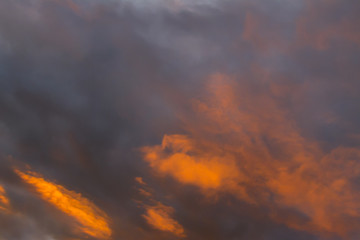 Fototapeta na wymiar Orange and dark grey clouds close up