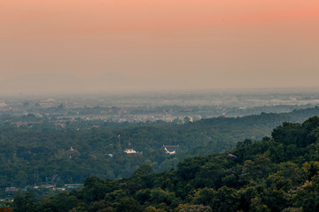 Fototapeta premium Blurry high angle nature background, which can see distant views (houses, mountains, trees, roads). The atmosphere is surrounded by the wind blowing through, seen at the natural viewpoint on the way.
