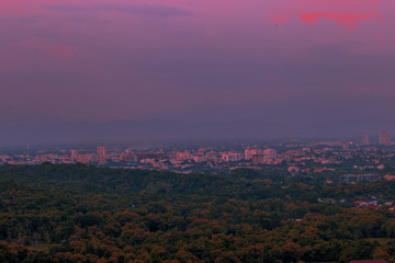 Blurry high angle nature background, which can see distant views (houses, mountains, trees, roads). The atmosphere is surrounded by the wind blowing through, seen at the natural viewpoint on the way.