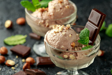 Chocolate Ice Cream with dark chocolate bars and hazelnuts in a glass bowl