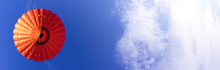 Red hot air balloon in a clear blue sky