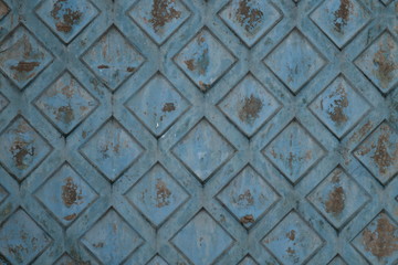 Texture of rhombus on the surface of a blue cement background with rust and smudges and scratches.