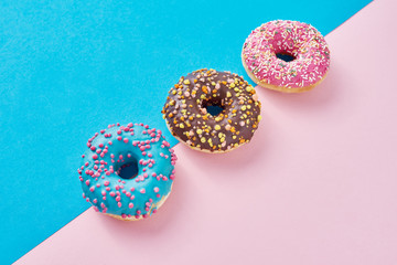 Donuts on a pastel pink and blue background. Minimalism creative food composition. Flat lay style