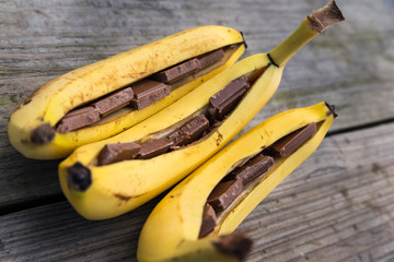 Three bananas filled with chocolate on a table