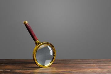 Magnifying glass on a wooden table. Search and analysis, analytics and study. Pay attention to...