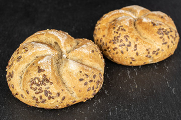 Group of two whole sesame kaiser roll on grey stone