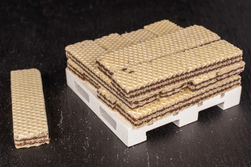 Lot of whole sweet chocolate biscuit wafer on white pallet on grey stone