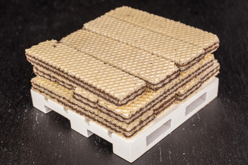 Lot of whole sweet chocolate biscuit wafer on white pallet on grey stone