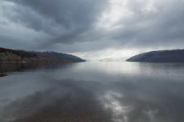 A view across Loch Ness looking down the length of the lake, with dark clouds above, in Scotland, UK