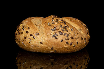 One whole sesame kaiser roll isolated on black glass